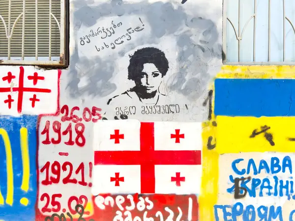 Tiflis, Gürcistan - 09 Mayıs 2025: Tiflis 'te Avrupa Birliği ve NATO üyeliğine destek veren Rus karşıtı graffiti. Rusya 'nın Ukrayna' yı işgali nedeniyle artan gerginlik. AB Ukrayna bayrakları. Yüksek