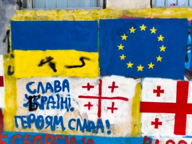 Tiflis, Gürcistan - 09 Mayıs 2025: Tiflis 'te Avrupa Birliği ve NATO üyeliğine destek veren Rus karşıtı graffiti. Rusya 'nın Ukrayna' yı işgali nedeniyle artan gerginlik. AB Ukrayna bayrakları. Yüksek