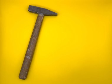Sarı arka planda ahşap saplı paslı eski çekiç. Düz yatıyordu. Üst görünüm, boşluğu kopyala. Yüksek kalite fotoğraf