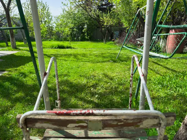 Çocuklar sıcak bir yaz gününde evinizin arka bahçesinde boş salıncak salıncak sallıyorlar. Yüksek kalite fotoğraf