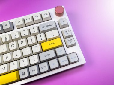 Programcı için beyaz ve gri klavye, mor arka planda, kırmızı düğmeli. Yüksek kalite fotoğraf