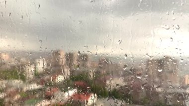 Pencere camına yağmur damlaları, arka plandaki binalar. Yüksek kalite 4k görüntü