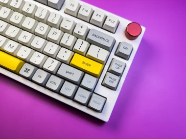 Modern mekanik klavye, mor arkaplanda kırmızı düğmeyle izole edilmiş. Minimal stil ve tasarım klavyesi. Renkli anahtar kapağı. Yüksek kalite fotoğraf
