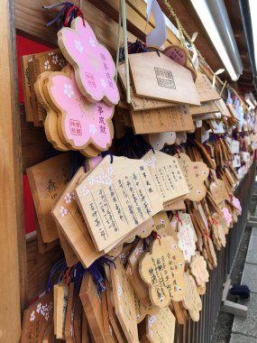Japonya Tokyo 01.02.2020 Yasukuni Jinja Wooden film plaketleri el yazısıyla yazılmış geleneksel Japon Şinto tapınağında sergilenmektedir. Fotoğraf, Japonya 'nın kültürel ve ruhsal özünü detaylı hat ve seren üzerine odaklanarak yakalıyor.