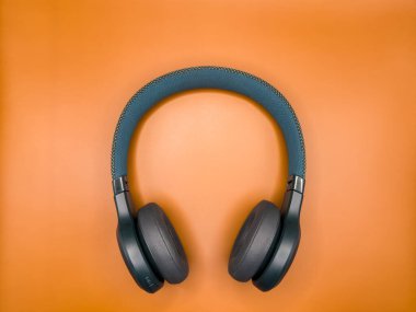 Açık turuncu arka planda koyu yeşil kulaklıklar, afişler ve reklamlar için. kopyalama alanı. Yüksek kalite fotoğraf