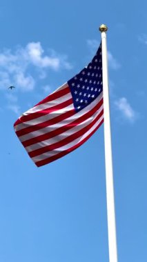 Mavi gökyüzünde büyük bir Amerikan bayrağı dalgalanıyor. Amerikan bayrağı. Amerikan bayrağı. Yüksek 4k kalite video