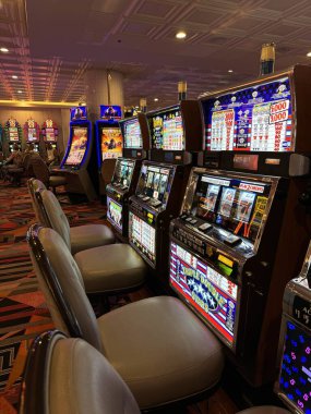 Nevada, ABD 09.17.2024 Birkaç kişinin oturduğu bir dizi eski kumar makinesi. Las Vegas gezisi. Kumar makineleri.