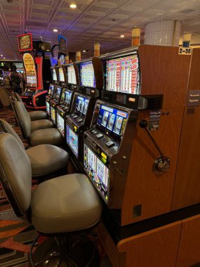 Nevada, ABD 09.17.2024 Birkaç kişinin oturduğu bir dizi eski kumar makinesi. Las Vegas gezisi. Kumar makineleri.