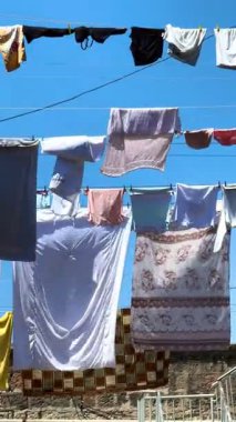 Çamaşır ipine asılmış bir takım elbise. Giysiler beyaz, pembe ve siyah.