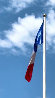 Mavi bir gökyüzü ve beyaz bir bayrak direğine karşı rüzgarda dalgalanan büyük bir Fransız bayrağı. Fransa, Paris, Avrupa, Avrupa 'nın başkenti, Avrupa' nın kalbi, haberler için, gazeteler için. Yüksek 4k kalite video