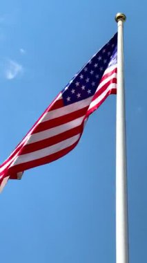 Gri gökyüzünde büyük bir Amerikan bayrağı dalgalanıyor. Amerikan bayrağı. Amerikan bayrağı. Yüksek 4k kalite video