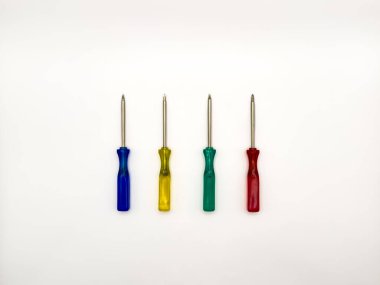 Beyaz arka planda dört küçük renkli plastik tornavida. Kopyalama alanı, deri döşeme, üst görünüm. Yüksek kalite fotoğraf.