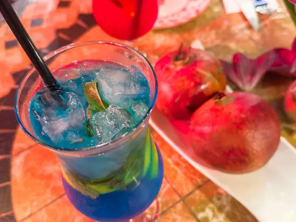 Kırmızı sulu nar arkaplanına karşı alkolsüz Mahito mavisi, kopyalama alanı. Yüksek kalite fotoğraf