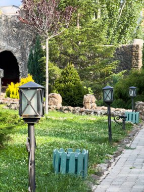 Arka bahçe yolu, bahçe yolu. Binanın önündeki çimlerin üzerinde bir sıra ışık var. Sol tarafta üç, sağ tarafta iki ışık var.