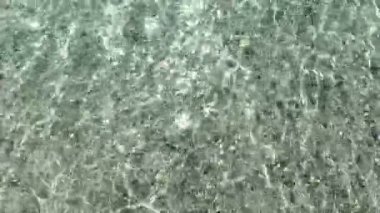 Deniz küçük dalgaları ve kristal berrak suyun üst görüntüsü. Ermenistan, Sevan. Yüksek kalite