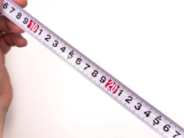 Ölçüm bandı, cetvel, inşaat alanı, beyaz arka plan. Elinde mezura tutan bir adam. Ölçüm aleti, tamir. Yüksek kalite fotoğraf