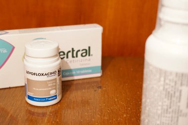 Puebla, Puebla, Meksika - 28 Mart 2023: Ahşap arka planı olan ahşap bir masanın üzerindeki ilaç şişelerinin editörel illüstrasyon manzarası