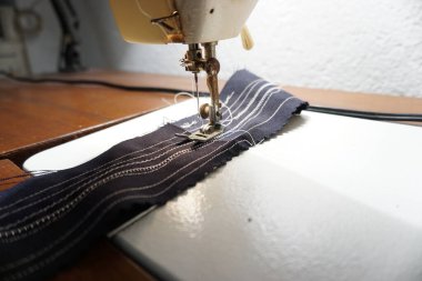 Tahta bir masanın üzerinde duran dikiş makinesinin ayrıntılı görüntüsü. Zanaat, DIY ve ev projesi görselleri için ideal.
