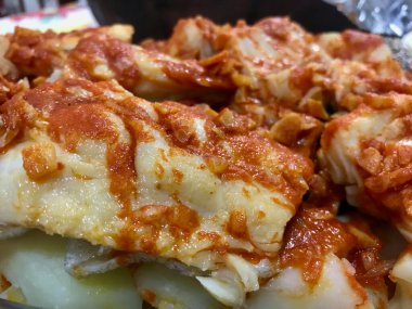 Bacalao a la Vizcana 'nın yakın çekimi, zengin kırmızı biber soslu geleneksel bir İspanyol morina yemeği..