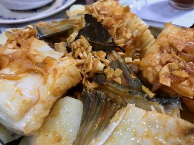 Geleneksel morina yemeği, sarımsak, kırmızı biber ve taze otlarla tatlandırılmış, köy usulü servis edilir..