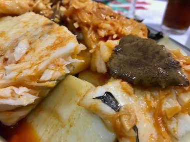 Geleneksel morina yemeği, sarımsak, kırmızı biber ve taze otlarla tatlandırılmış, köy usulü servis edilir..