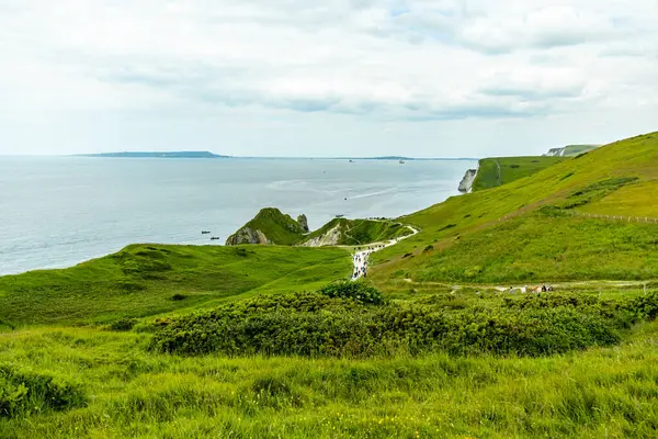 Lulworth Koyu ile Lulworth-İngiltere yakınlarındaki Durdle Kapısı arasındaki Güney Batı Yakası Yolu 'nda seyahat ediyor.