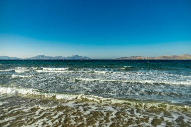 A short walk on the beach around the beautiful salt lake at Marmari in the South Aegean with a view of a few flamingos - Greece  clipart