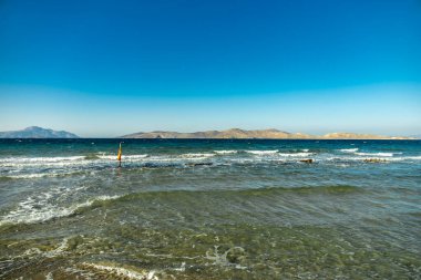 A short walk on the beach around the beautiful salt lake at Marmari in the South Aegean with a view of a few flamingos - Greece  clipart