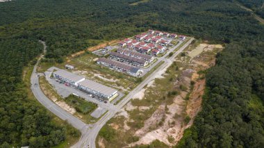 Fotoğraf, beyaz, yeni bir ticari binanın havadan görüntüsünü ve yeni bir gelişim bölgesindeki altyapıyı gösteriyor.