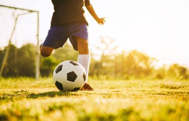 Çocukların dışarıda futbol oynayarak eğlendiği bir spor. Toplumun kırsal kesimlerinde alacakaranlık günbatımı gökyüzünün altında. Kopyalama alanı ile resim.