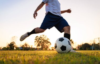 Çocukların dışarıda futbol oynayarak eğlendiği bir spor. Toplumun kırsal kesimlerinde alacakaranlık günbatımı gökyüzünün altında. Kopyalama alanı ile resim.