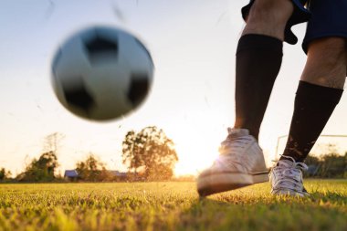 Çocukların dışarıda futbol oynayarak eğlendiği bir spor. Toplumun kırsal kesimlerinde alacakaranlık günbatımı gökyüzünün altında. Kopyalama alanı ile resim.