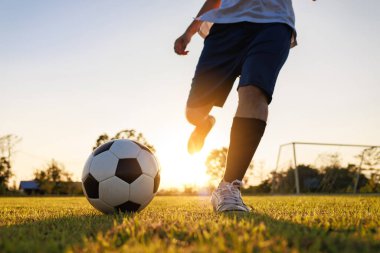 Çocukların dışarıda futbol oynayarak eğlendiği bir spor. Toplumun kırsal kesimlerinde alacakaranlık günbatımı gökyüzünün altında. Kopyalama alanı ile resim.