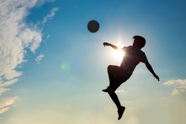 Çocukların dışarıda futbol oynayarak eğlendiği bir spor. Toplumun kırsal kesimlerinde alacakaranlık günbatımı gökyüzünün altında. Kopyalama alanı ile resim.