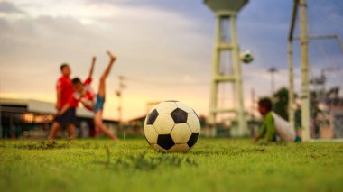 Çocukların dışarıda futbol oynayarak eğlendiği bir spor. Toplumun kırsal kesimlerinde alacakaranlık günbatımı gökyüzünün altında. Kopyalama alanı ile resim.