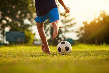 Çocukların dışarıda futbol oynayarak eğlendiği bir spor. Toplumun kırsal kesimlerinde alacakaranlık günbatımı gökyüzünün altında. Kopyalama alanı ile resim.