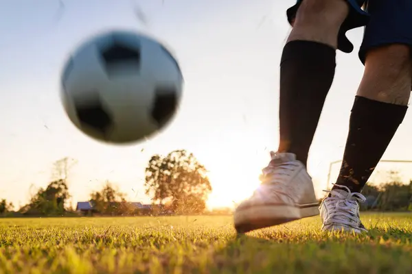 Çocukların dışarıda futbol oynayarak eğlendiği bir spor. Toplumun kırsal kesimlerinde alacakaranlık günbatımı gökyüzünün altında. Kopyalama alanı ile resim.