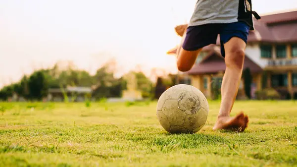 Çocukların dışarıda futbol oynayarak eğlendiği bir spor. Toplumun kırsal kesimlerinde alacakaranlık günbatımı gökyüzünün altında. Kopyalama alanı ile resim.