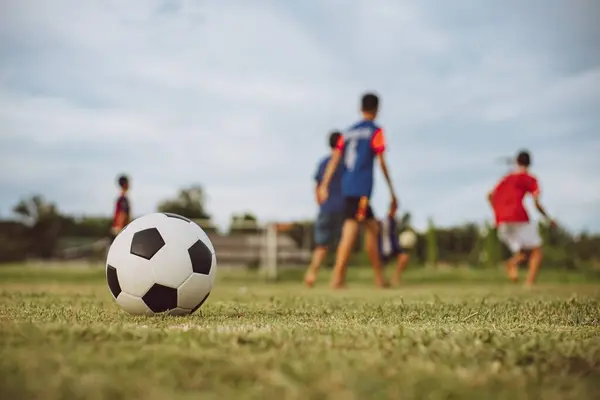 Çocukların dışarıda futbol oynayarak eğlendiği bir spor. Toplumun kırsal kesimlerinde alacakaranlık günbatımı gökyüzünün altında. Kopyalama alanı ile resim.