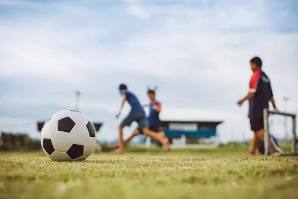 Çocukların dışarıda futbol oynayarak eğlendiği bir spor. Toplumun kırsal kesimlerinde alacakaranlık günbatımı gökyüzünün altında. Kopyalama alanı ile resim.