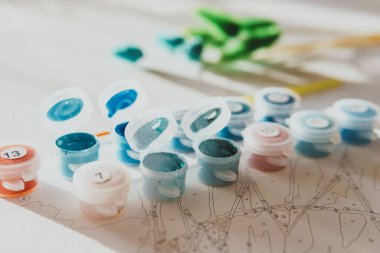 Sayılarla, pastel renklerle, tuvale çizim yapmak için renkli bir guaj seti. Boş zaman aktivitesi, hobi ve rahatlama kavramları. Seçici odaklanma. Kapat..