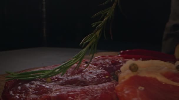 유기농 쇠고기 고기와 로즈마리 과붉은 고추가 배경에 매크로를 클로즈업합니다 스테이크를 — 비디오