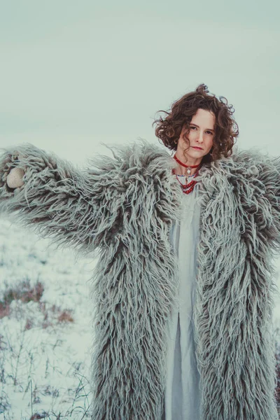 Woman in Historical Ukrainian winter clothing - gunia, sheepskin coat. Hutsul traditional winter casing