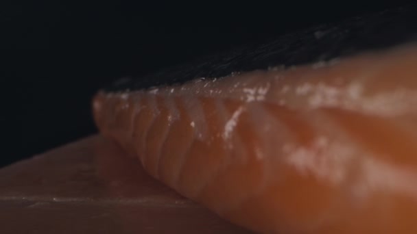 調味料やハーブと新鮮な生サーモンフィレ 黒の背景にクローズアップ 魚を調理する準備 スローモーション — ストック動画