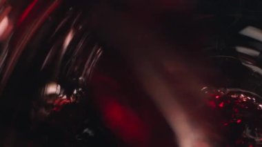 Şarap kadehine kırmızı şarap dökmek, makro yakın plan, seçici odaklanma. Yavaş çekim 