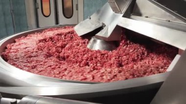 Endüstriyel et öğütücüsünde kıyma işleniyor, yakın plan. Gıda endüstrisindeki modern teknolojiler