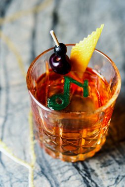 Alcoholic drink. A cocktail with elite alcohol on dark black background, close-up. Concept of  nightlife and exotic drinks.