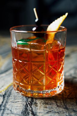 Alcoholic drink. A cocktail with elite alcohol on dark black background, close-up. Concept of  nightlife and exotic drinks.