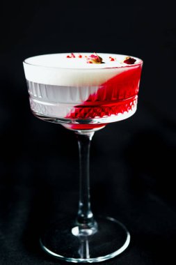 Alcoholic drink. A cocktail with elite alcohol on dark black background, close-up. Concept of  nightlife and exotic drinks.