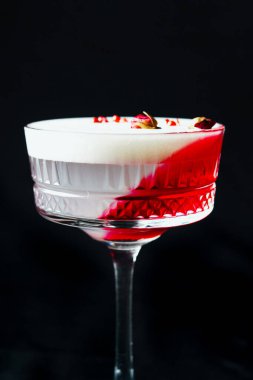 Alcoholic drink. A cocktail with elite alcohol on dark black background, close-up. Concept of  nightlife and exotic drinks.